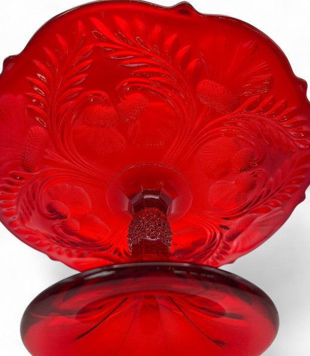 Red glass dish with intricate patterns on a white background