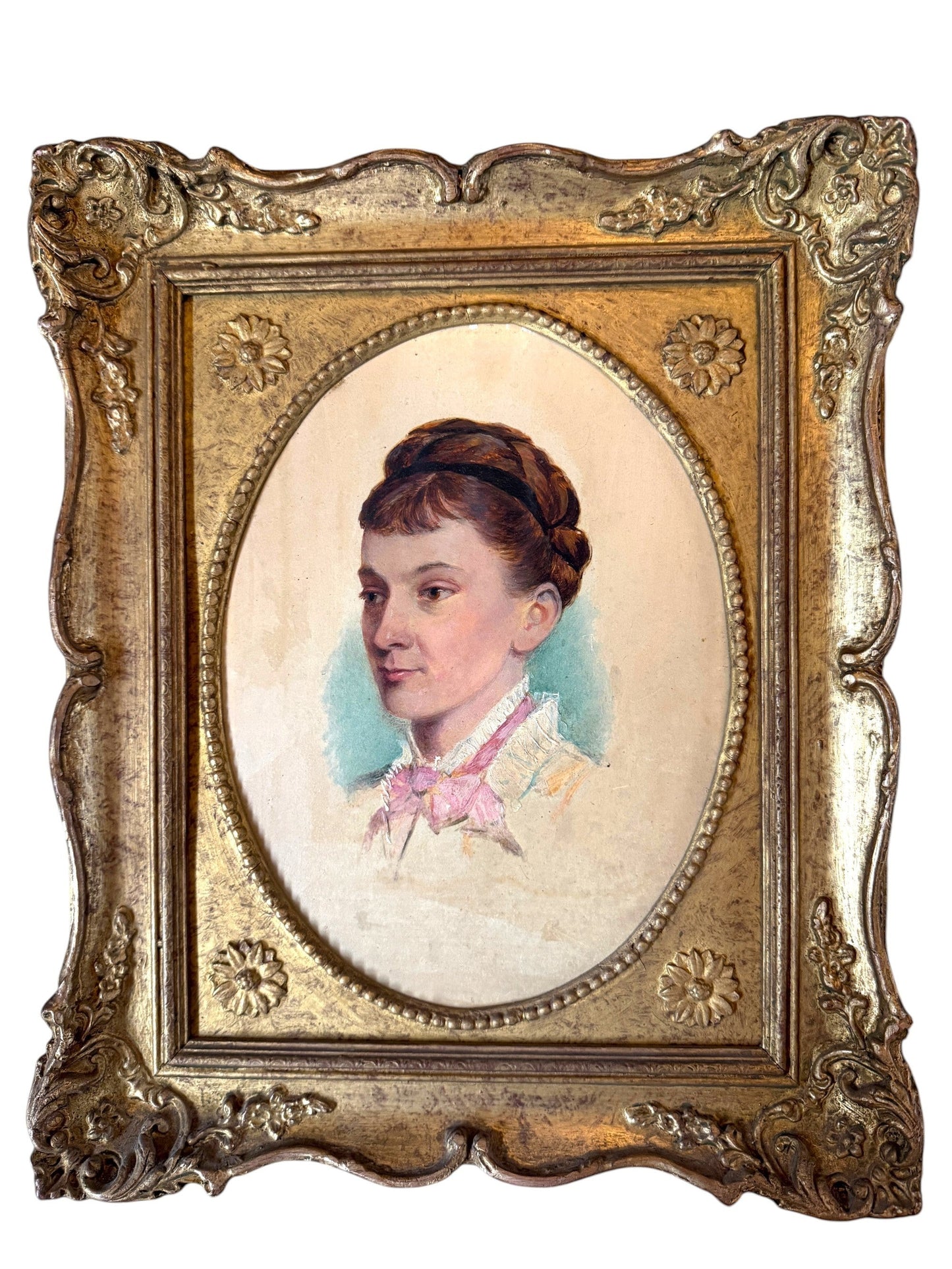 Hinson Vintage Interiors antique oval portrait of a lady in an ornate gold-toned frame with floral scrollwork.