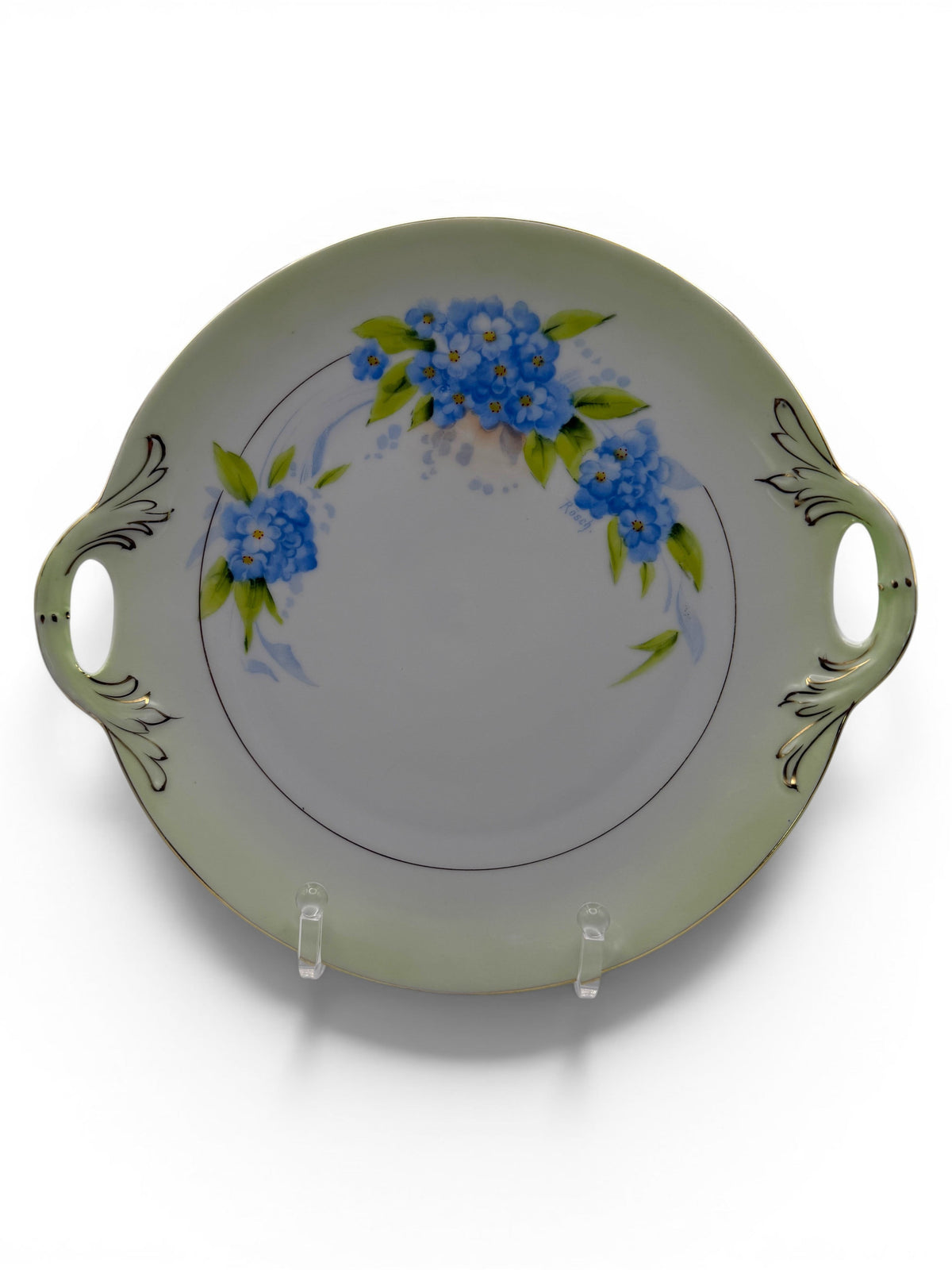 Hinson Vintage Interiors Bavaria Rosch porcelain cake plate with blue floral sprays, gold trim, and side handles.