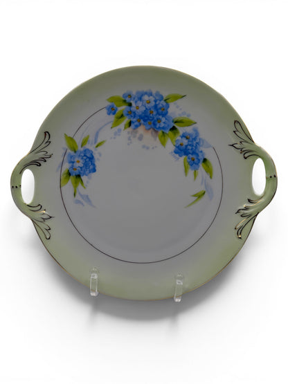 Hinson Vintage Interiors Bavaria Rosch porcelain cake plate with blue floral sprays, gold trim, and side handles.