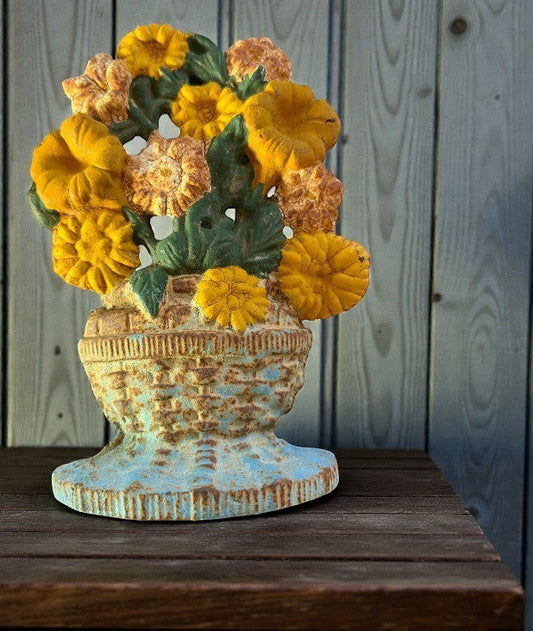 Hinson Vintage Interiors antique Hubley cast iron flower basket doorstop with turquoise base and golden yellow blooms.