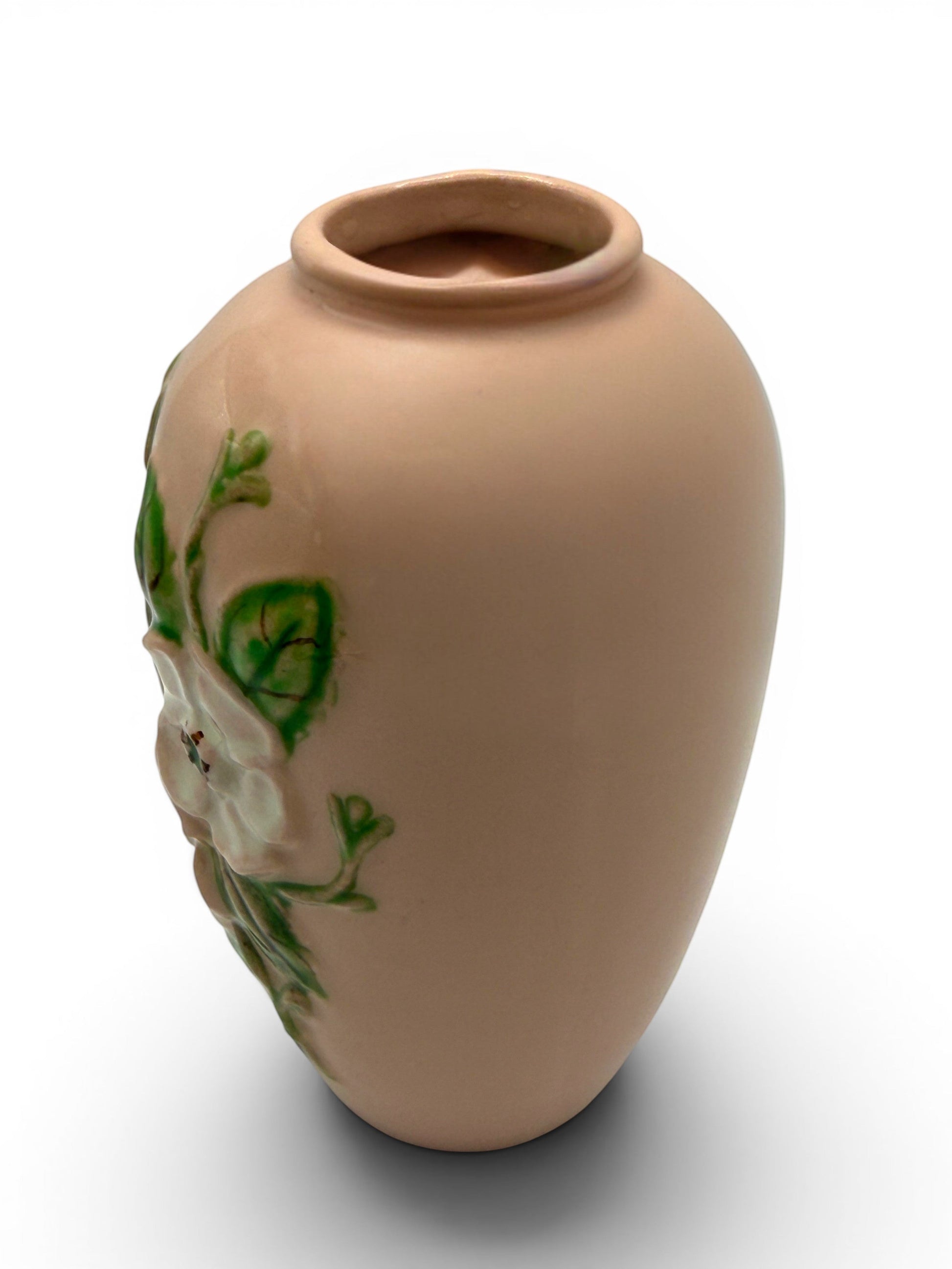 Hinson Vintage Interiors blush pink Hull Pottery vase with raised white floral and green leaf relief detail.