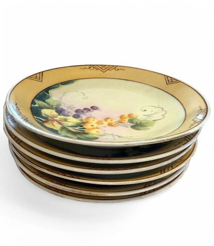 Hinson Vintage Interiors set of six hand-painted Nippon porcelain plates featuring grape motifs and golden borders.