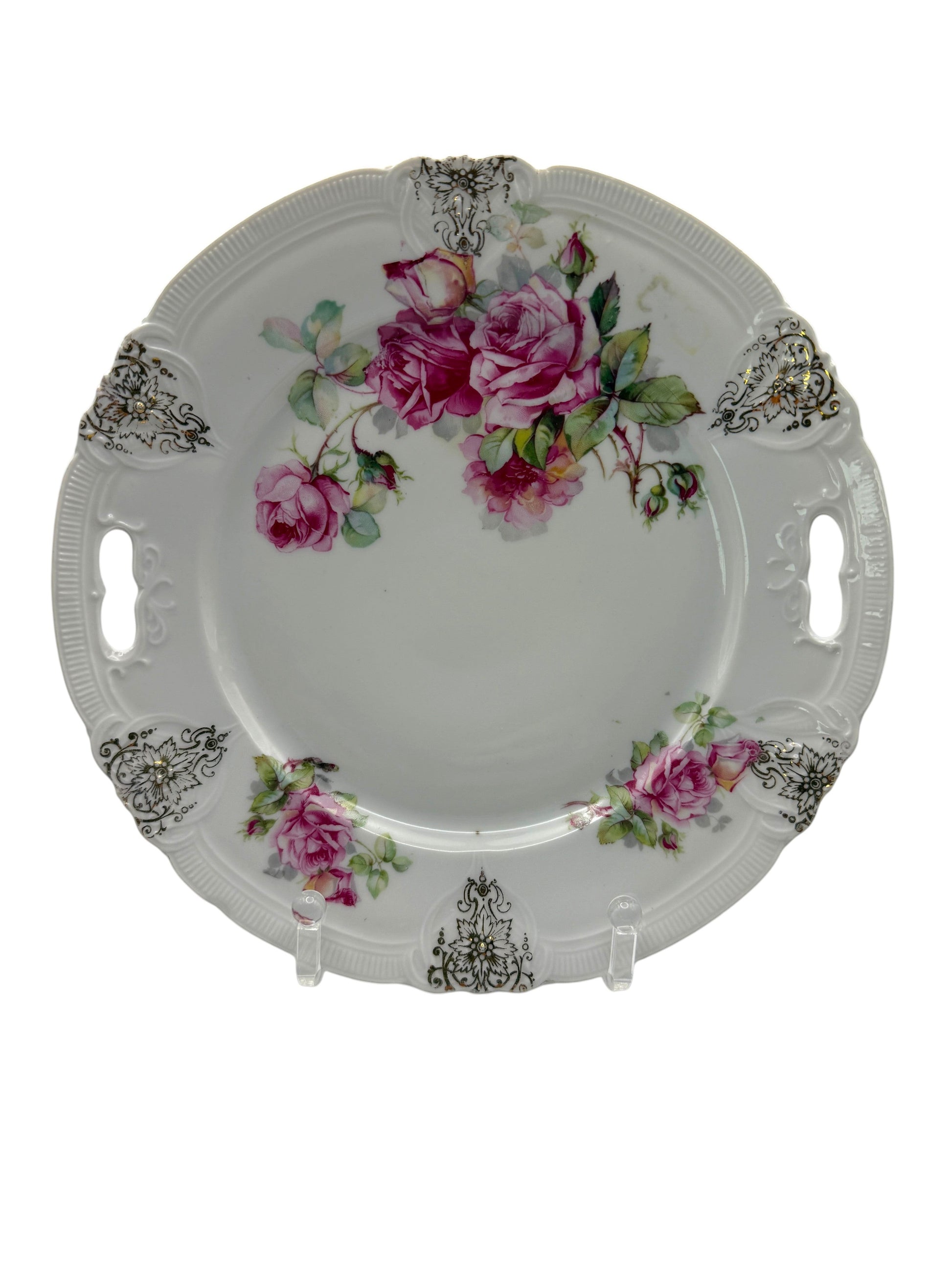 Hinson Vintage Interiors porcelain cake plate with pink roses, green leaves, and black-and-gold scroll accents.