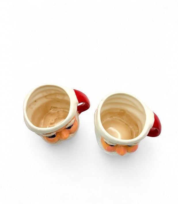 Hinson Vintage Interiors set of two hand-painted ceramic Santa Claus mugs with red handles, 1950s Japanese design.